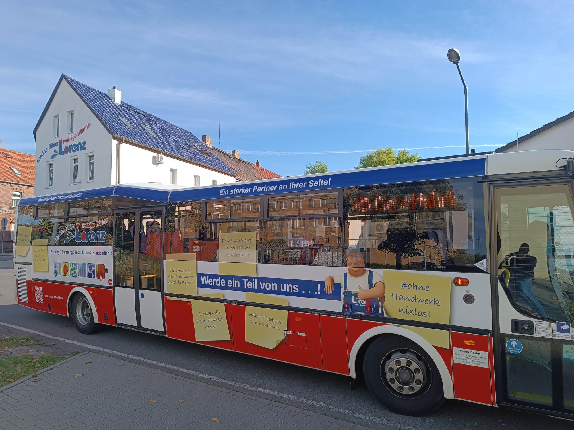Dieses Bild zeigt einen Bus von der rechten Seite welcher mit Werbung für Lorenz bedruckt ist.